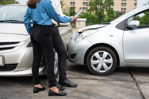 Two drivers exchanging insurance information after a t-bone car accident